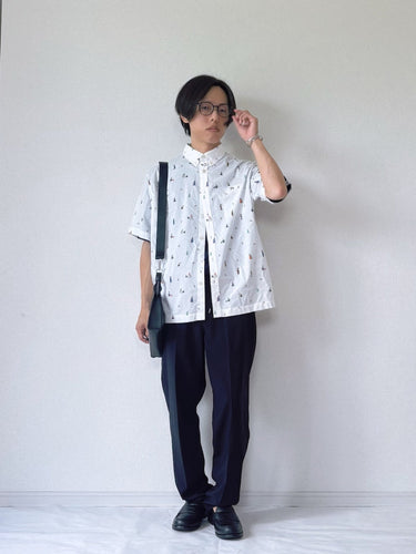 白ベースの総柄シャツと黒のパンツで爽やかにまとめたクリーンな夏コーデ。